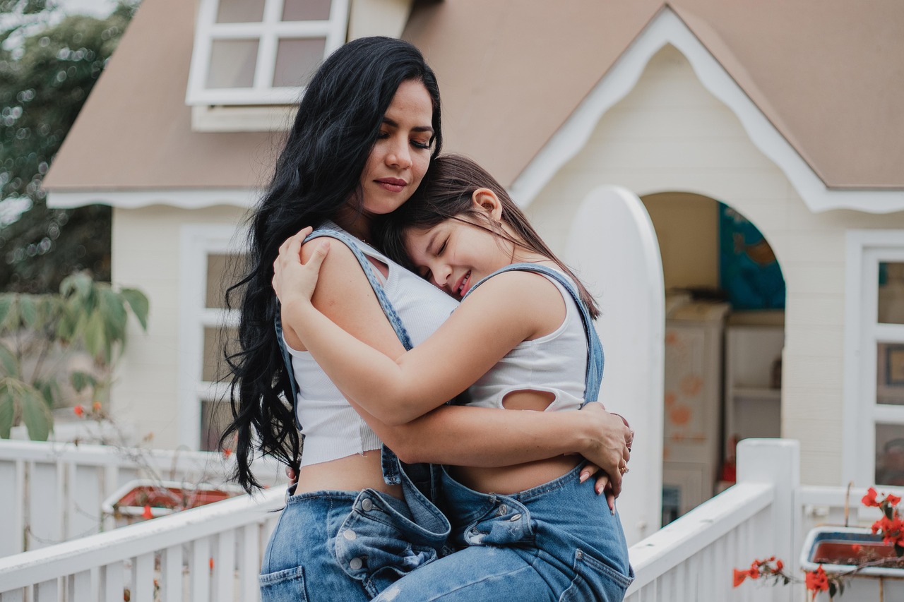 A mother and daughter embracing outside their home